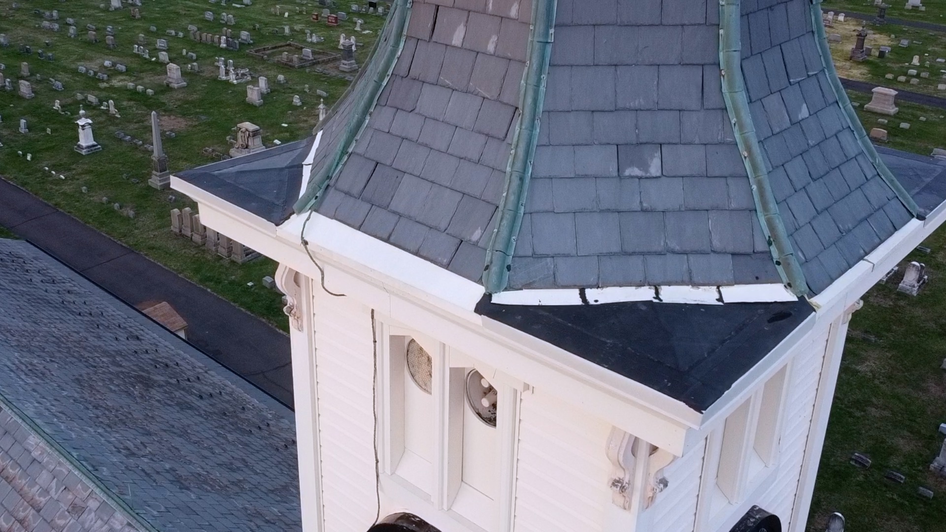 Aerial drone inspection of church steeple corner roofline and gutter condition